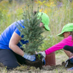 http://Young%20women%20and%20child%20planting%20a%20tree.