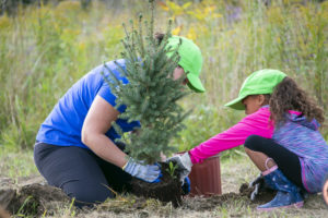 Young women and child planting a tree.
