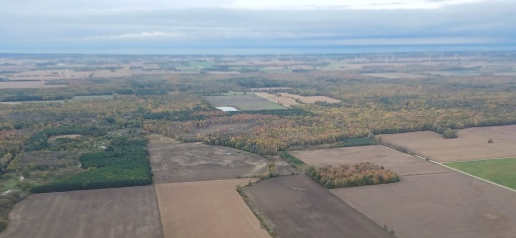 An aerial view of different farming lands with forests sections.