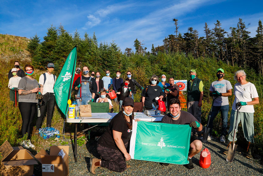 Group of community tree planters holding a Tree Canada sign.