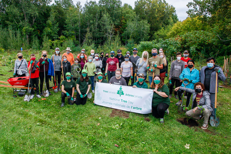 Group of people at a tree planting site with a National Tree Day sign.