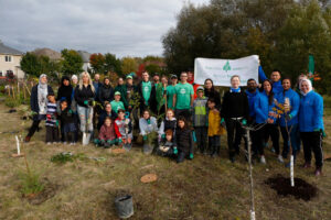 Group of people standing together at a tree planting event.