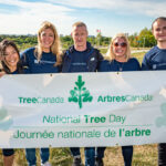http://Sponsor%20volunteers%20posing%20with%20the%20National%20Tree%20Day%20banner.