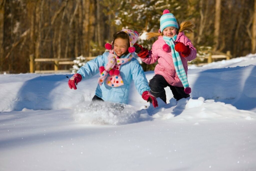 Pair of girls running in the snow